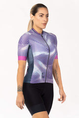 A feminine cycling top featuring short arm coverage. The top has a chic and fashionable design with a mix of textures and prints. It provides a snug fit and is constructed with a fabric that offers UV protection for sunny rides.